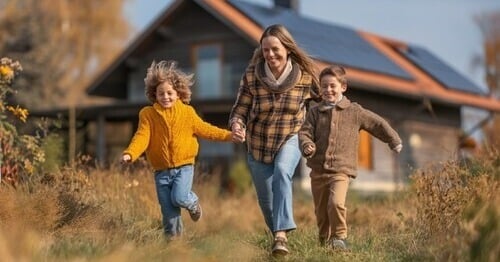 woman and children running in front of solar home
